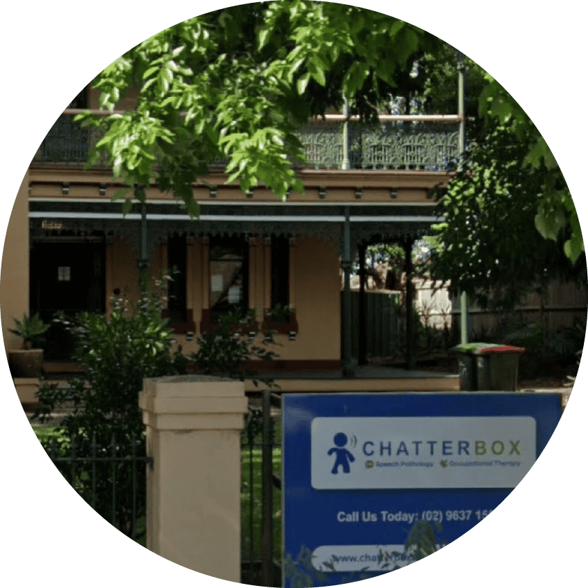 Quiet residential home with Chatterbox Speech therapy signage in front, surrounded by lush greenery in a neighbourhood setting.