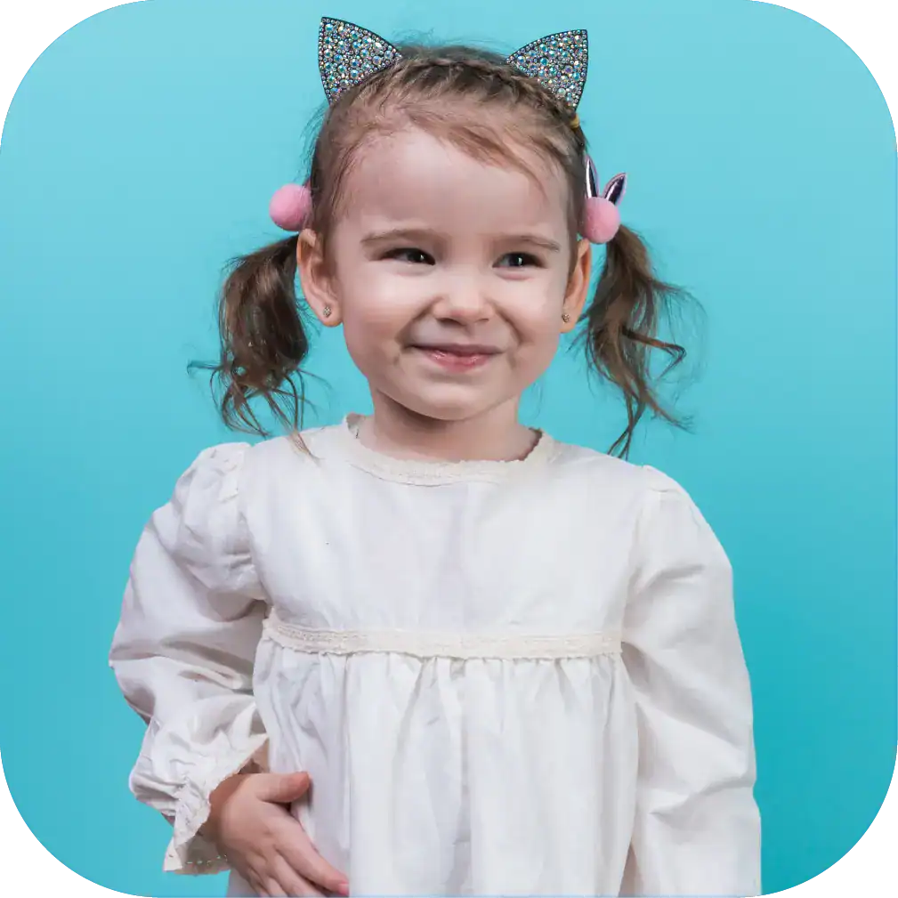 Bright young girl with playful accessories, smiling confidently – perfect for speech therapy and communication skills development.