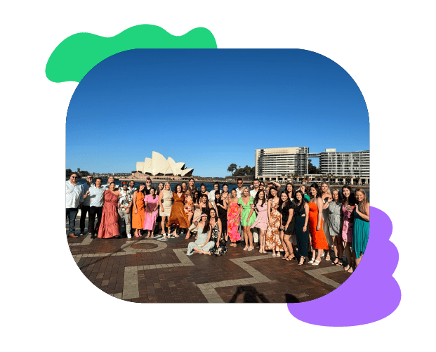 Group of diverse people celebrating outdoor event with Sydney Opera House and harbour view in background, promoting speech and communication skills training.