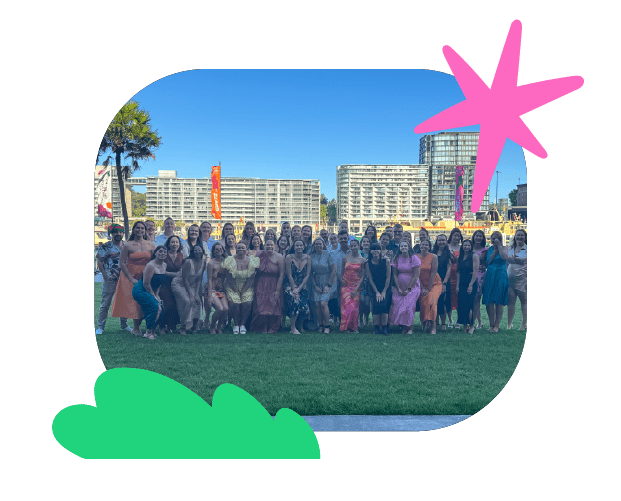 Vibrant group photo of adults participating in a public speaking workshop by Chatterbox Speech, outdoors with city skyline and colorful decorations, promoting confidence in communication skills.