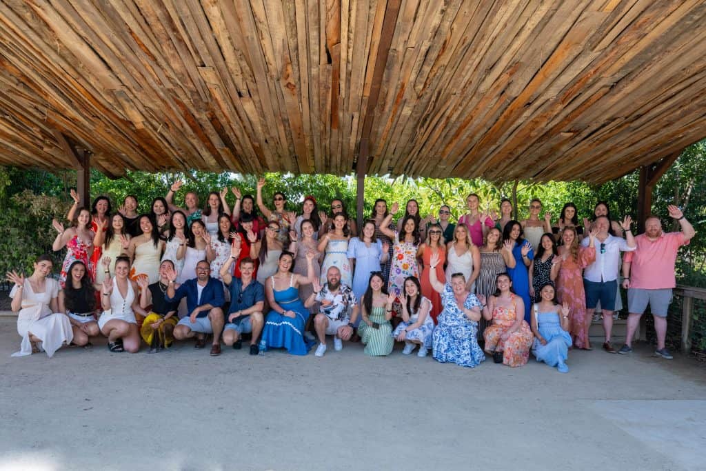 Active listening and speech development workshop group photo in tropical outdoor setting.