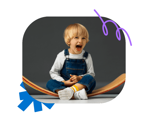 Bright young boy with blonde hair laughing and sitting on a musical instrument, promoting children's speech and communication development from Chatterbox Speech in Australia.