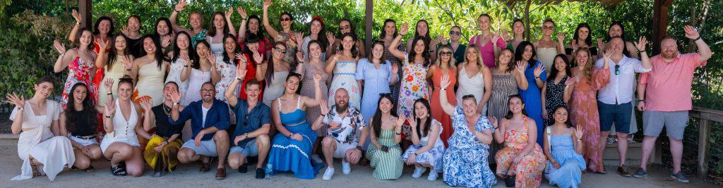 Vibrant group photo of diverse individuals at a Chatterbox Speech event in a lush outdoor setting in Australia.